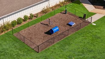 A garden bed with a blue cover and a fence.